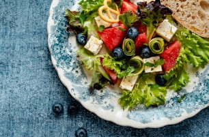 a blue and white plate topped with a salad