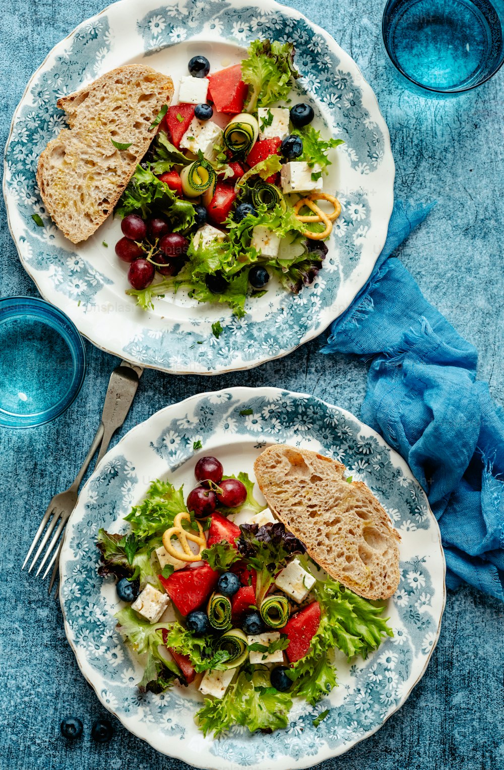 two plates of food on a blue table cloth