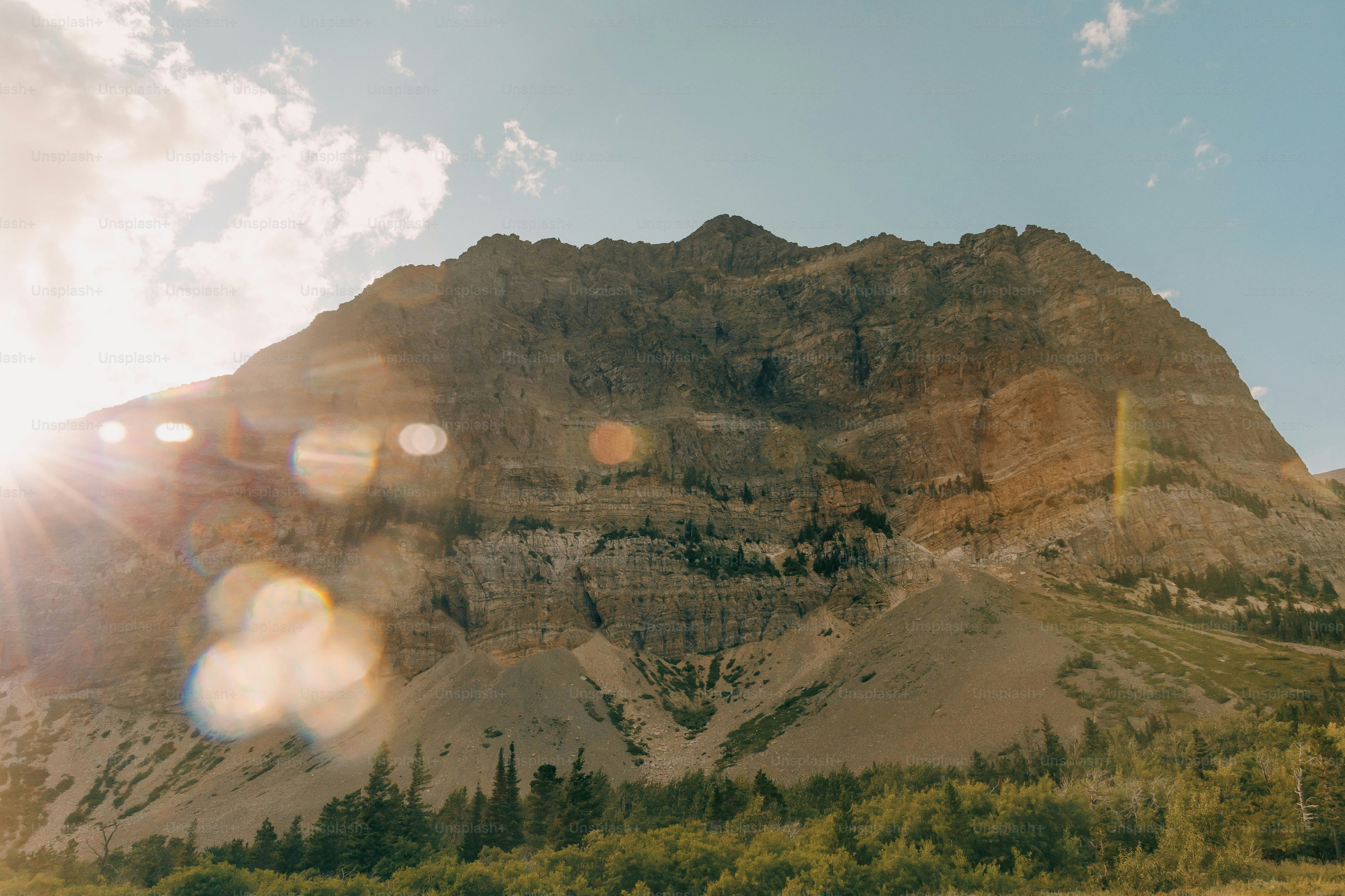 the sun shines brightly on a mountain side