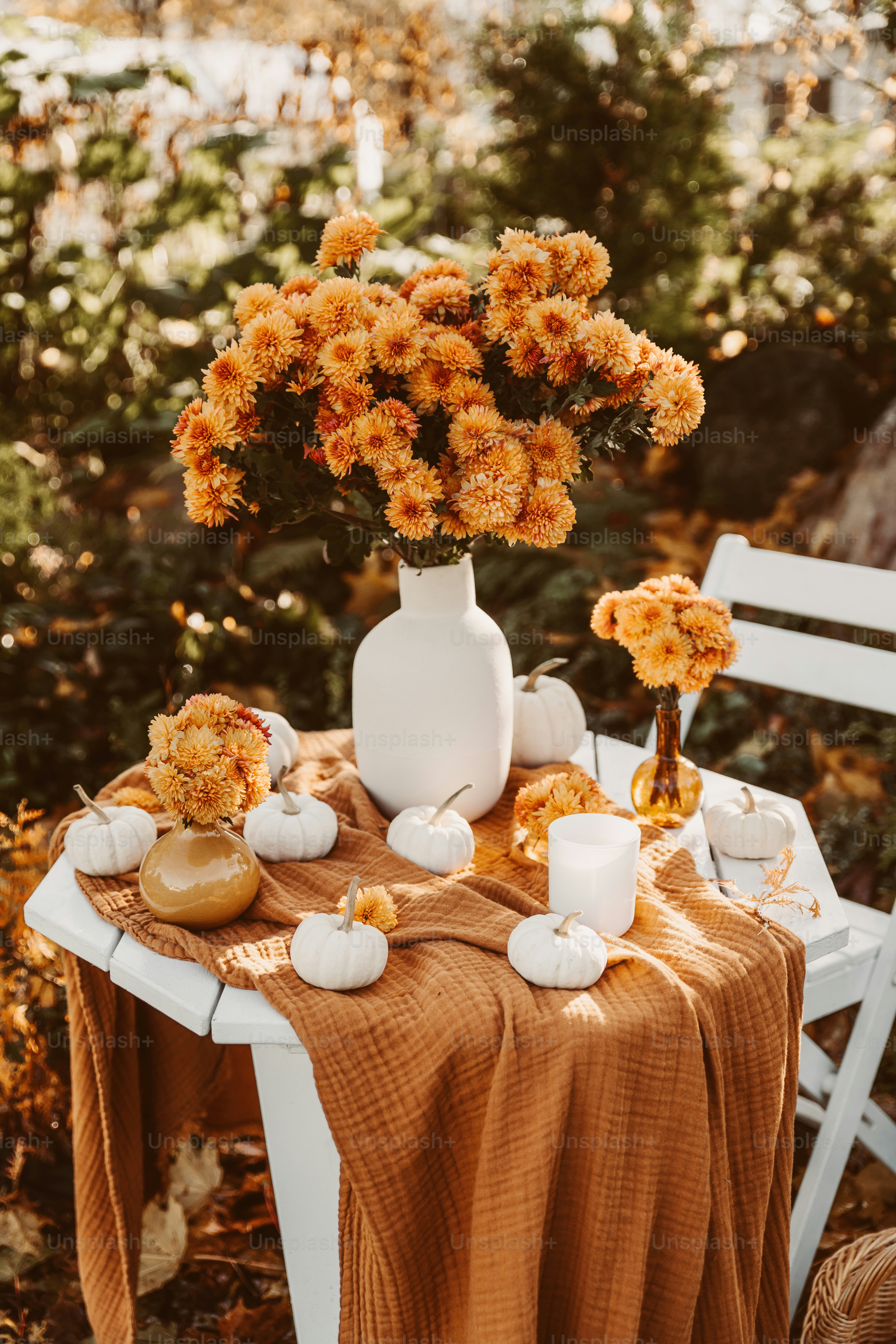 a table topped with a white vase filled with flowers