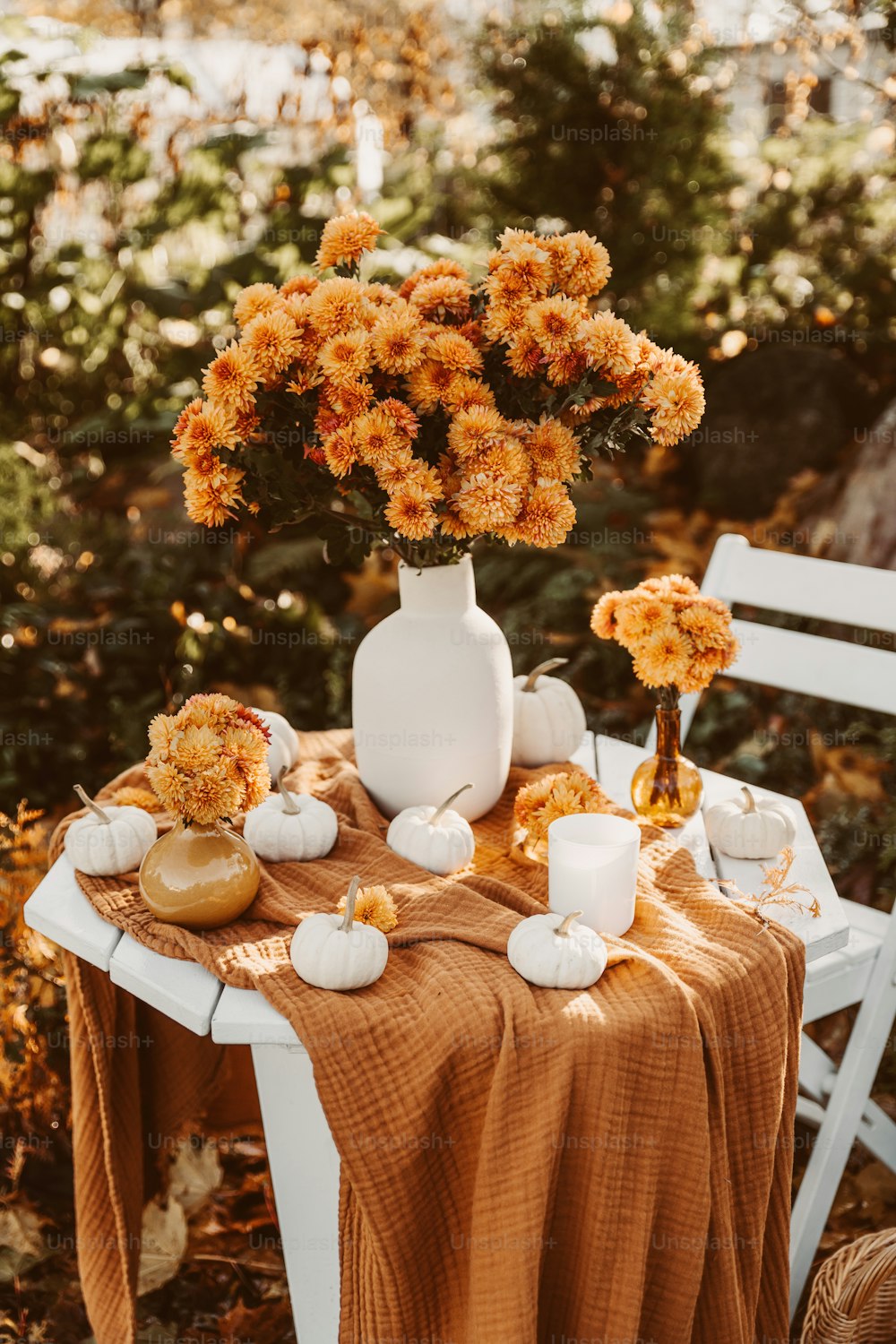 uma mesa coberta com um vaso branco cheio de flores