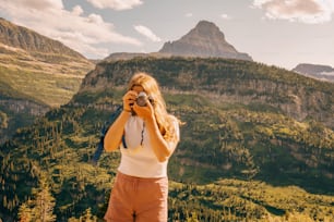 a woman taking a picture of a mountain