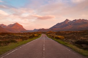 an empty road with mountains in the background