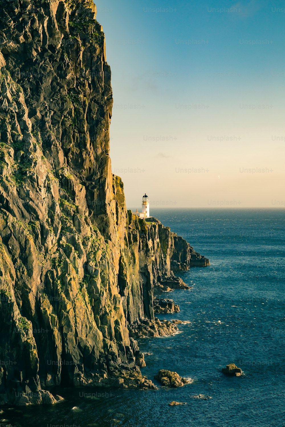 a lighthouse on a cliff overlooking the ocean