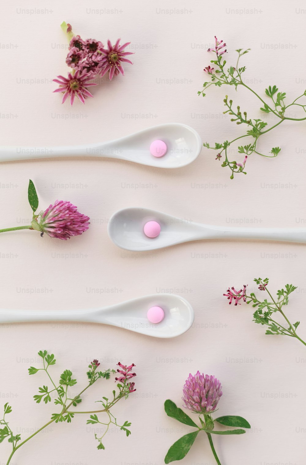 three spoons filled with flowers on top of a table