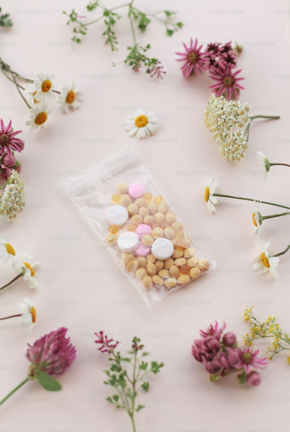 un sac de pilules posé sur une table à côté de fleurs