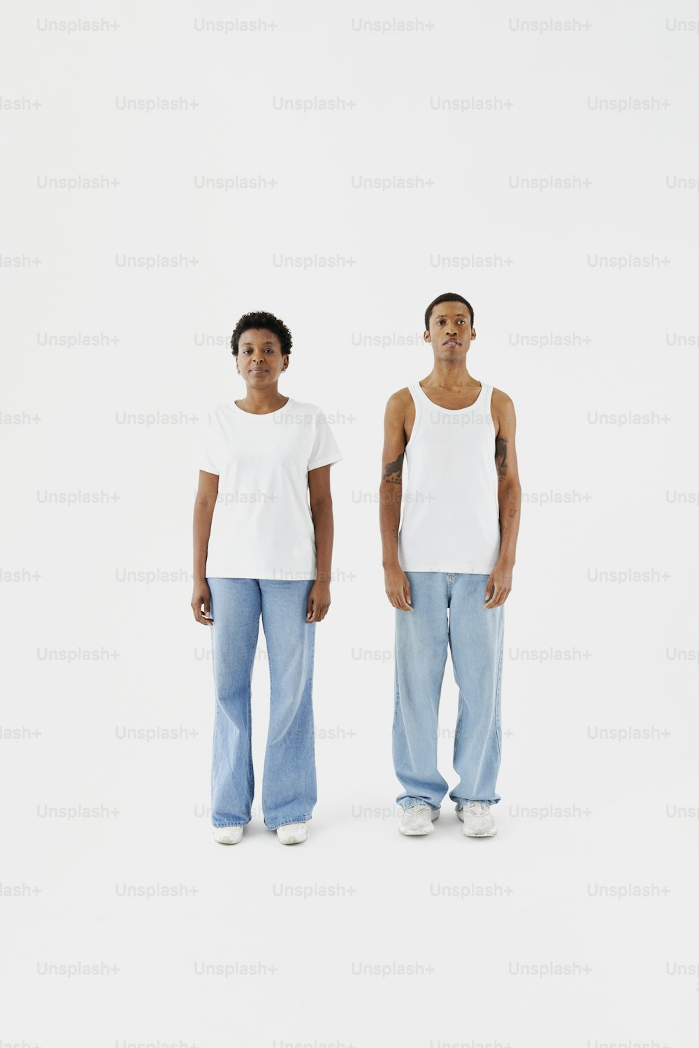 two people standing next to each other in front of a white background