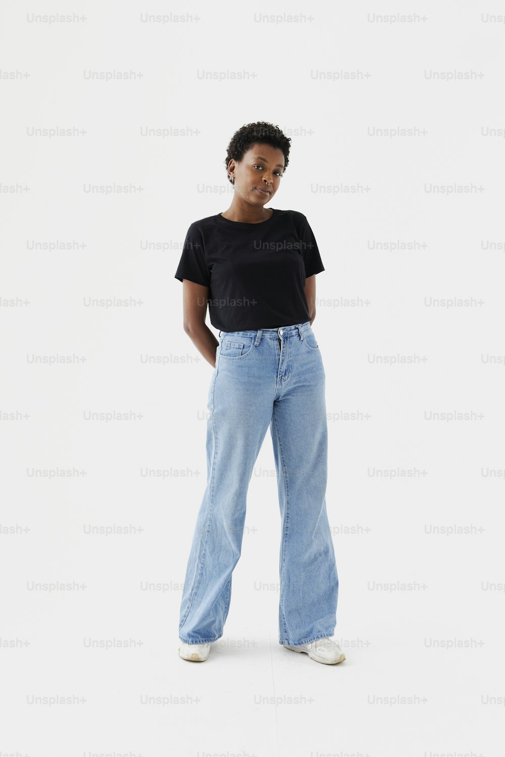 Eine Frau in schwarzem T-Shirt und hellblauen Jeans