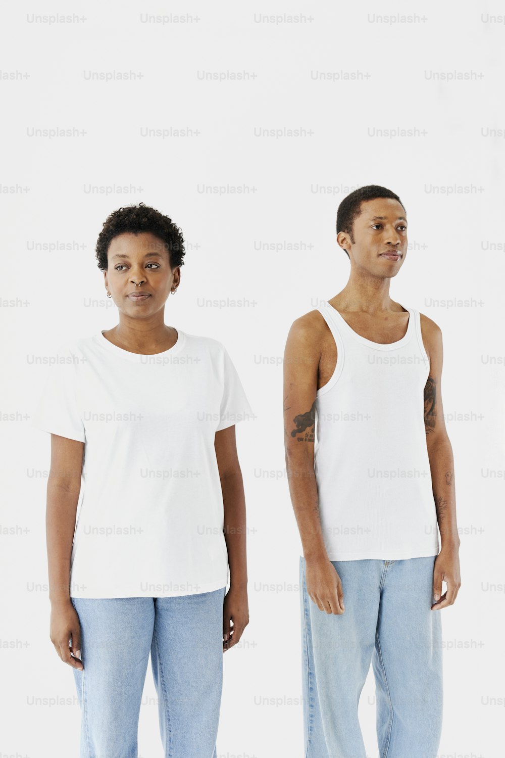 two men standing next to each other in front of a white background