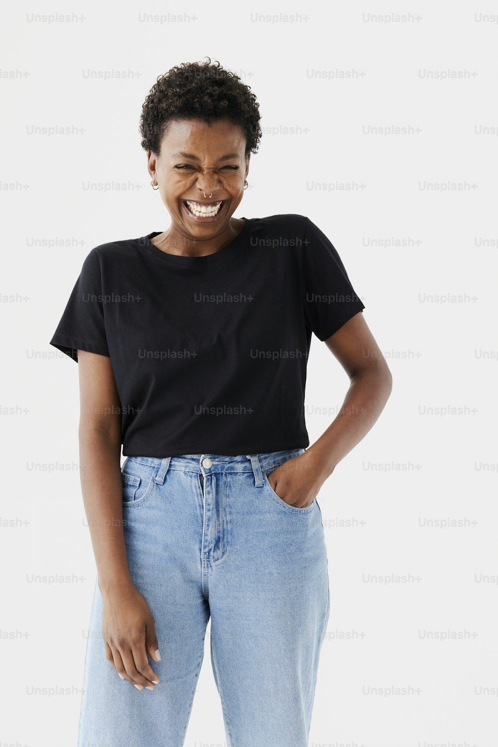 Una mujer sonriente con camisa negra y jeans