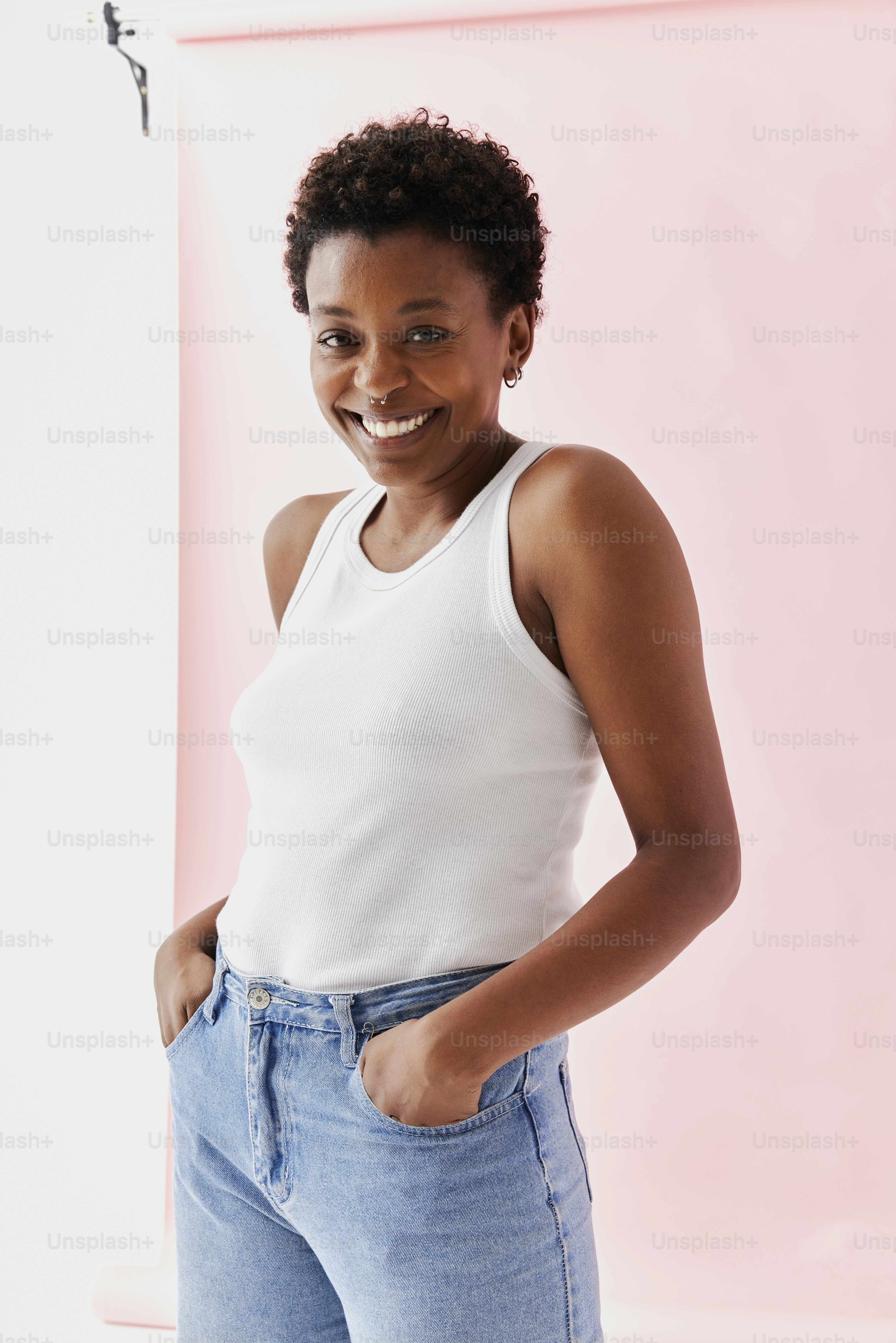 a woman in a white tank top is smiling