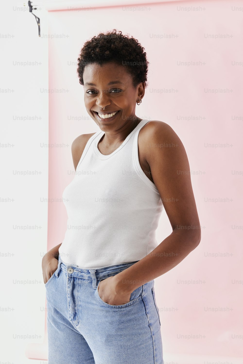 a woman in a white tank top is smiling