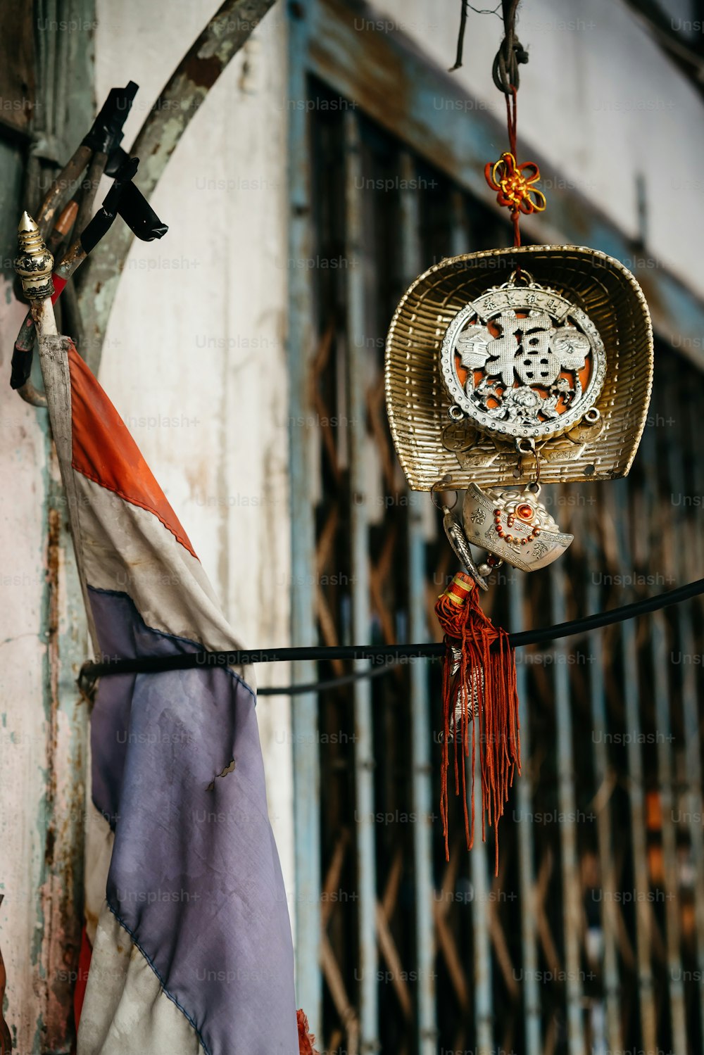 a clock hanging from a wire next to a building