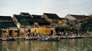 a group of people standing on a pier next to a body of water