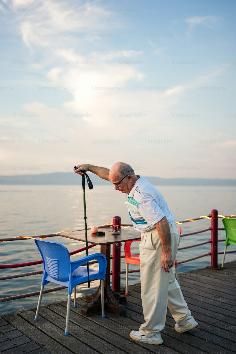 a man standing next to a table on a pier