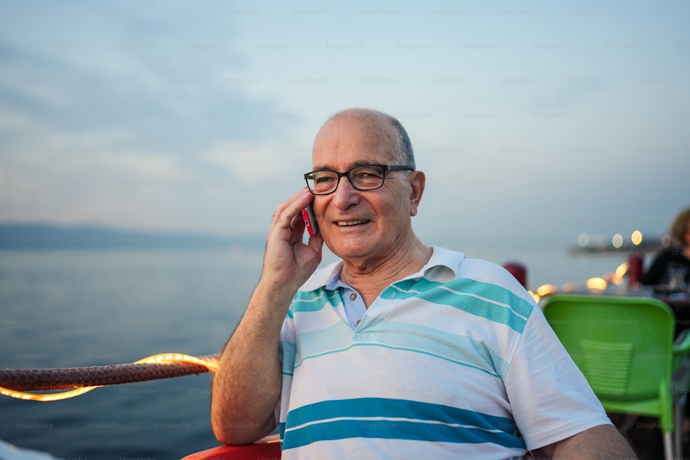 um homem sentado em um barco falando ao celular
