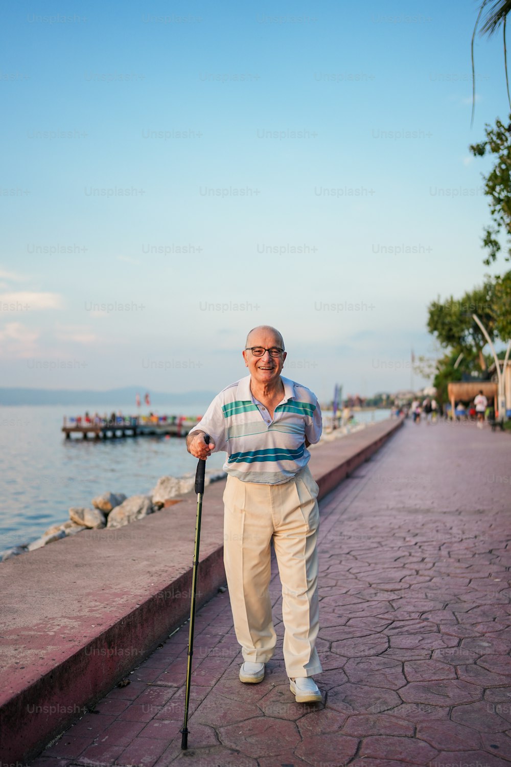 a man standing on a sidewalk next to a body of water
