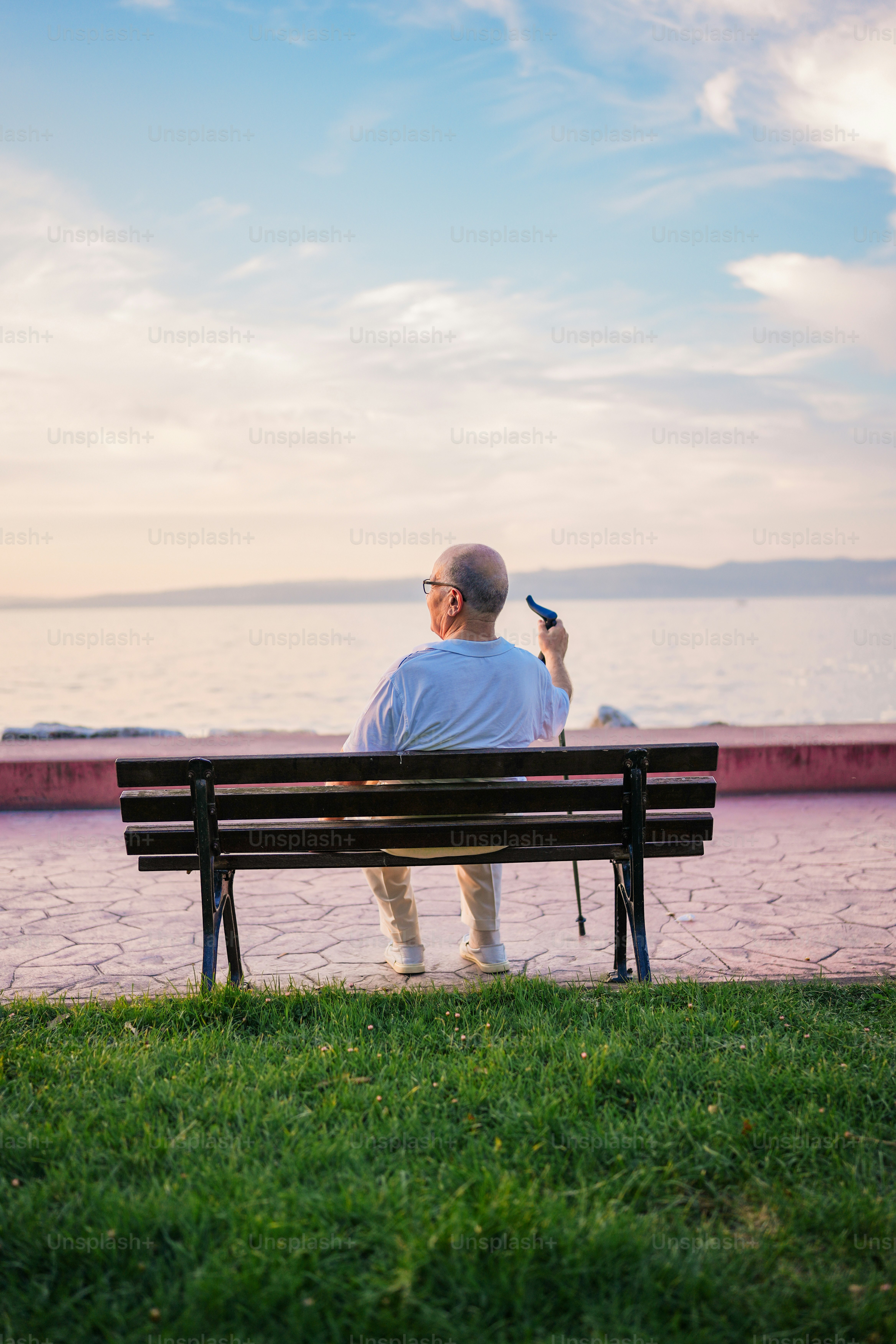海の隣のベンチの上に座っている男