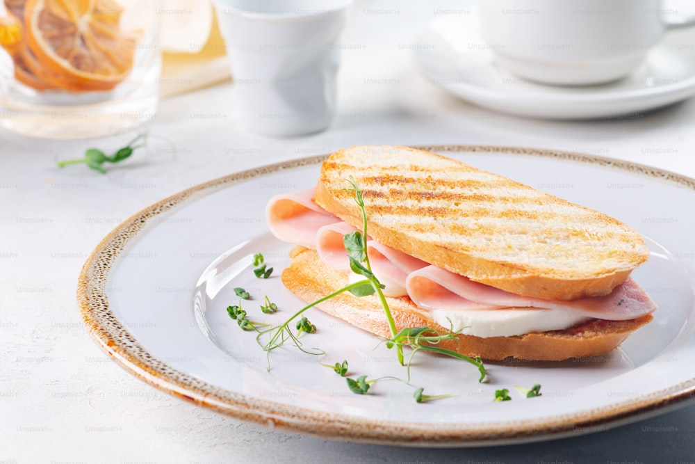 a sandwich with ham and cheese on a plate