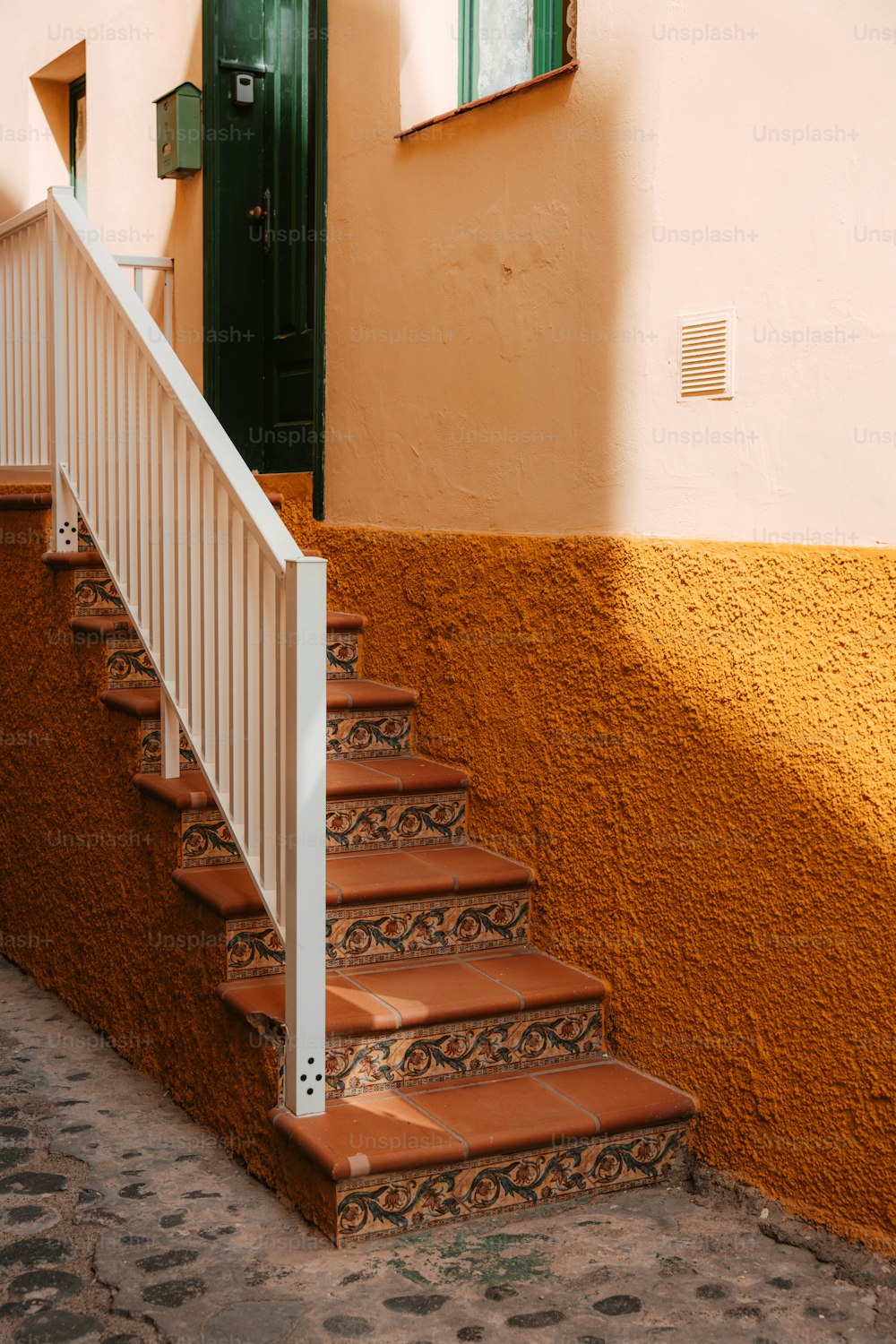 a set of stairs leading up to a green door