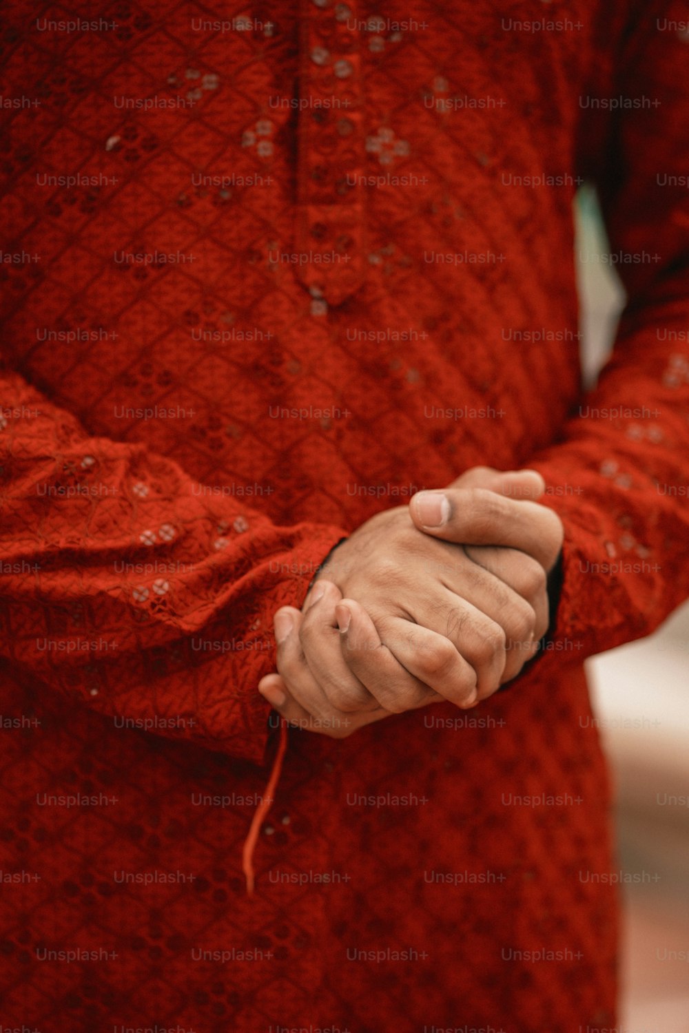 eine Person in einem roten Pullover, die Händchen hält