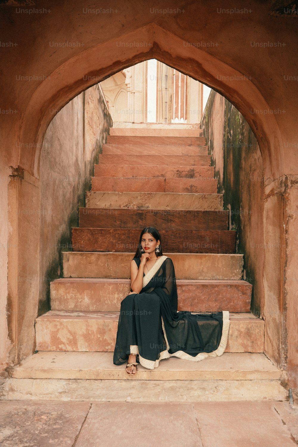 Una mujer sentada en los escalones de un edificio