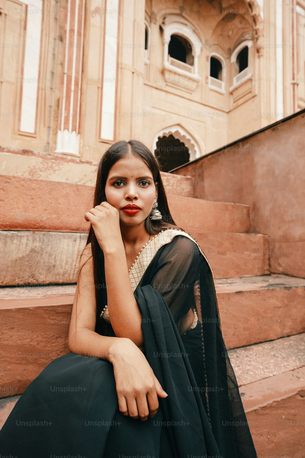 a woman sitting on the steps of a building