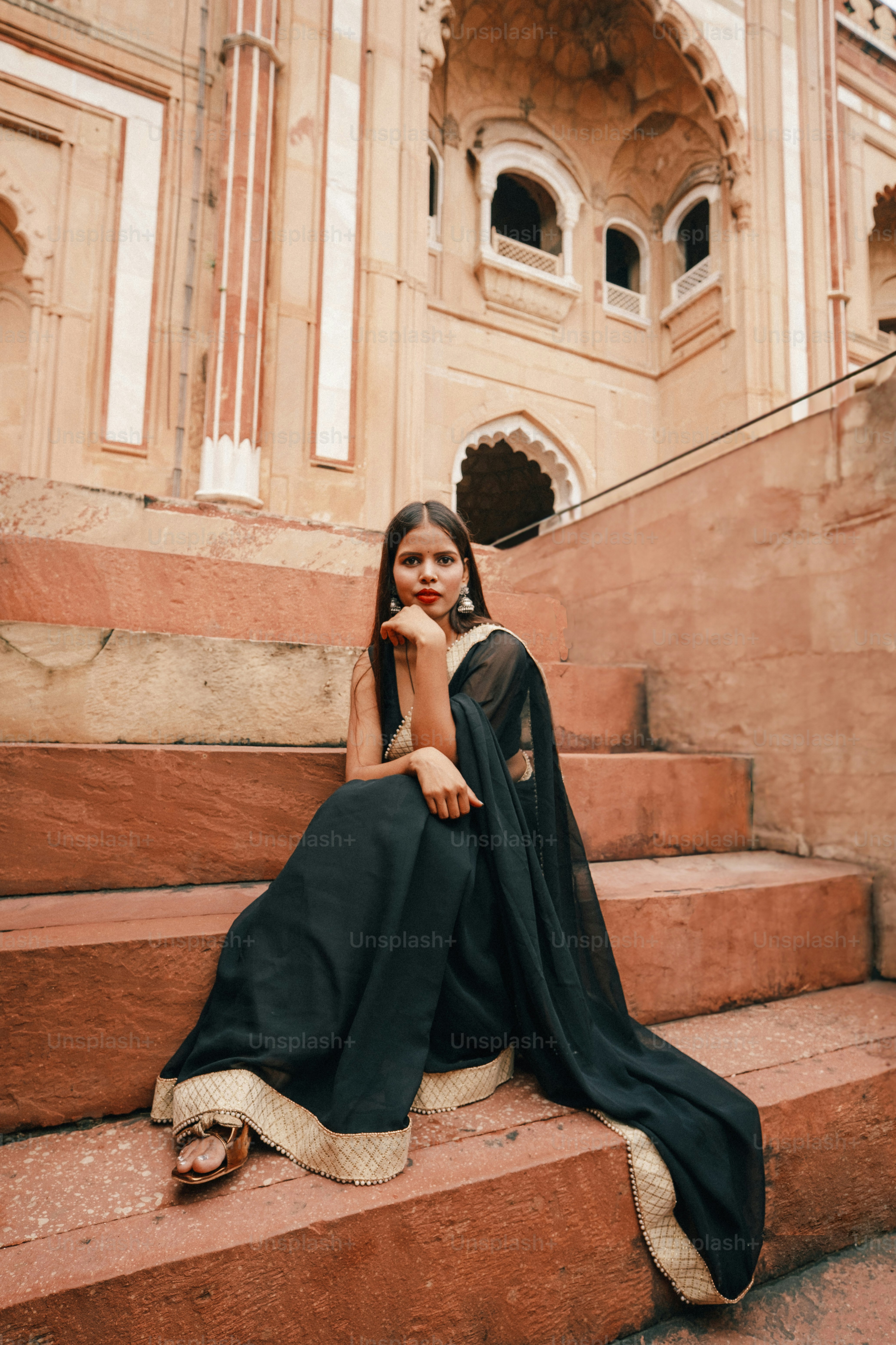 eine frau, die auf einigen stufen vor einem gebäude sitzt