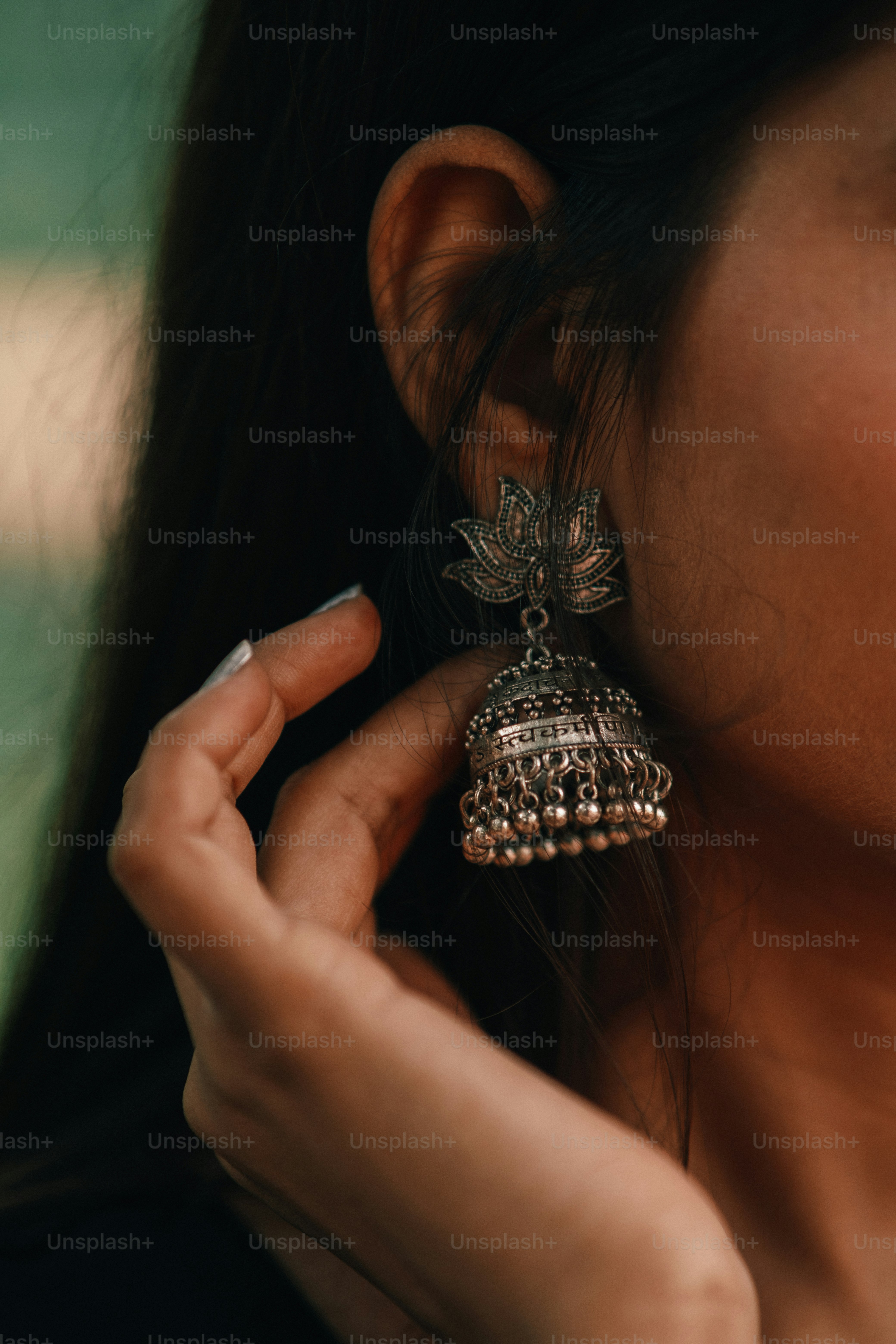 a close up of a person wearing a pair of earrings