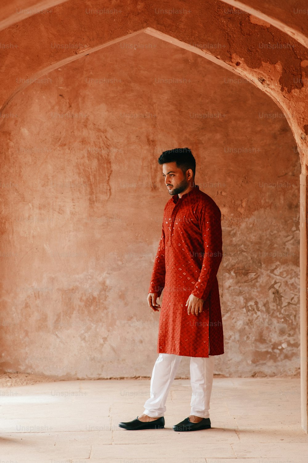 a man in a red outfit standing in a room