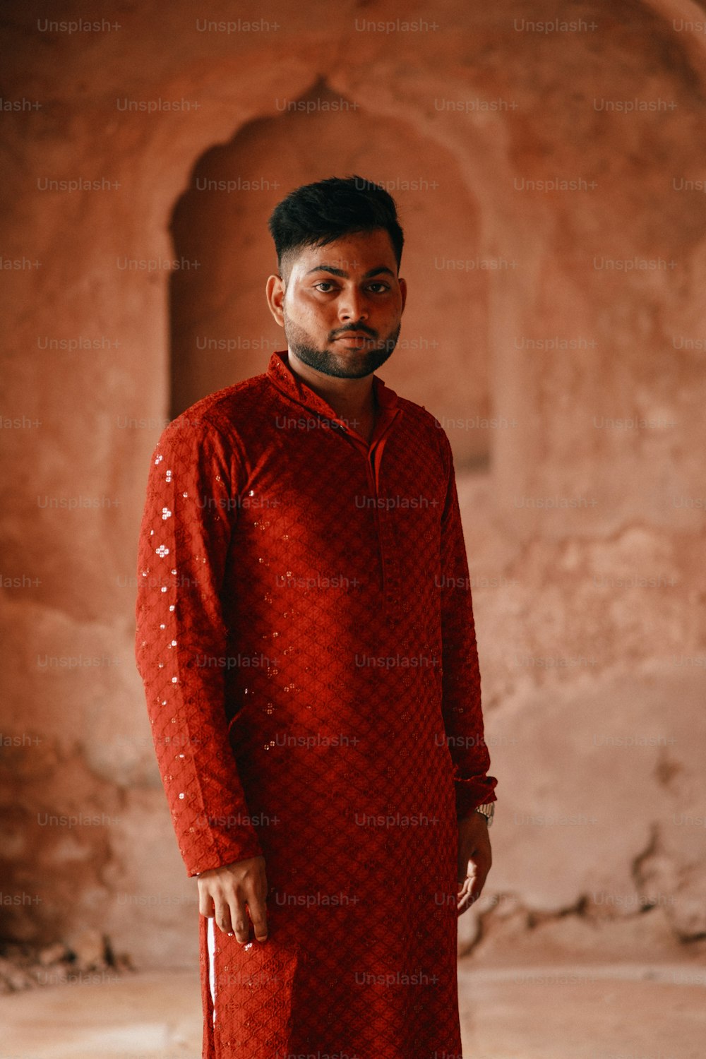 a man in a red outfit standing in a room