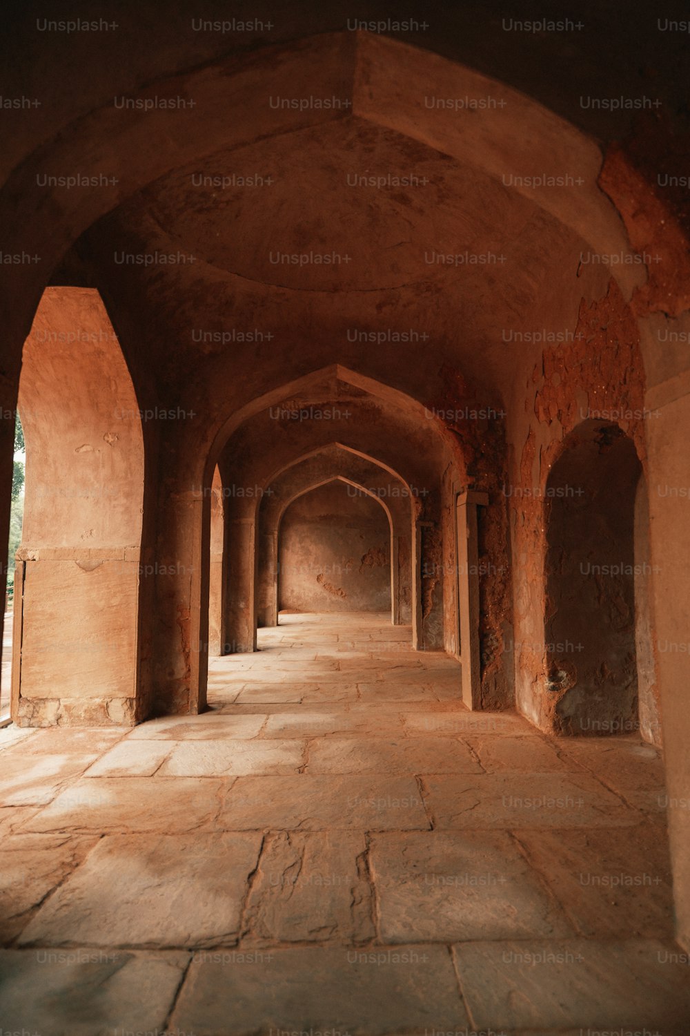 a long hallway with stone walls and arches