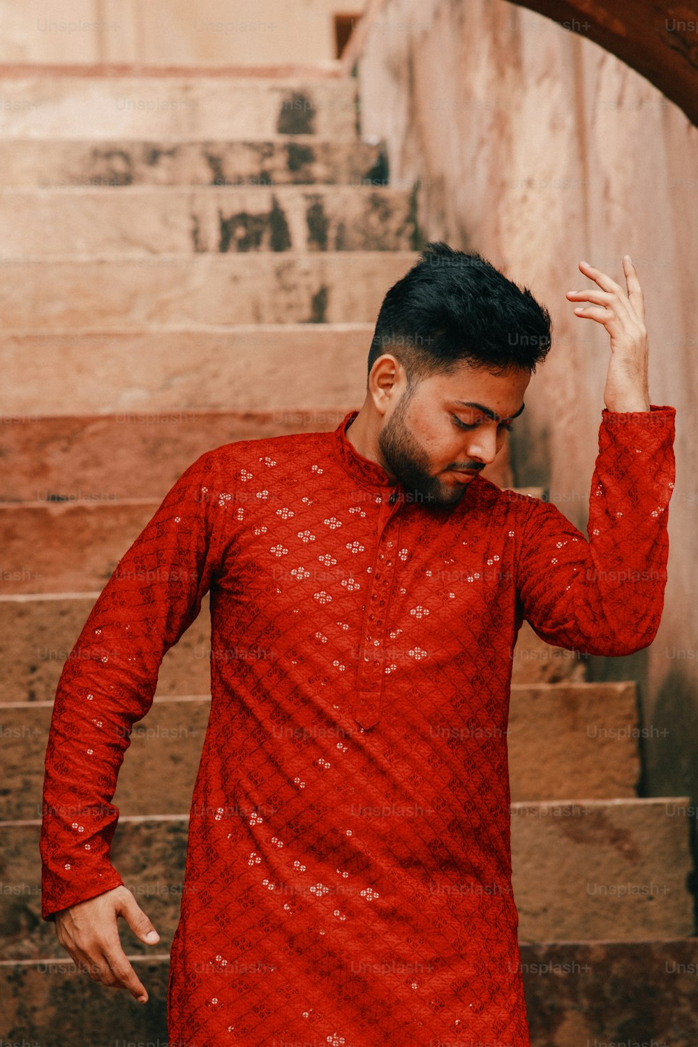 a man in a red shirt is standing on some steps