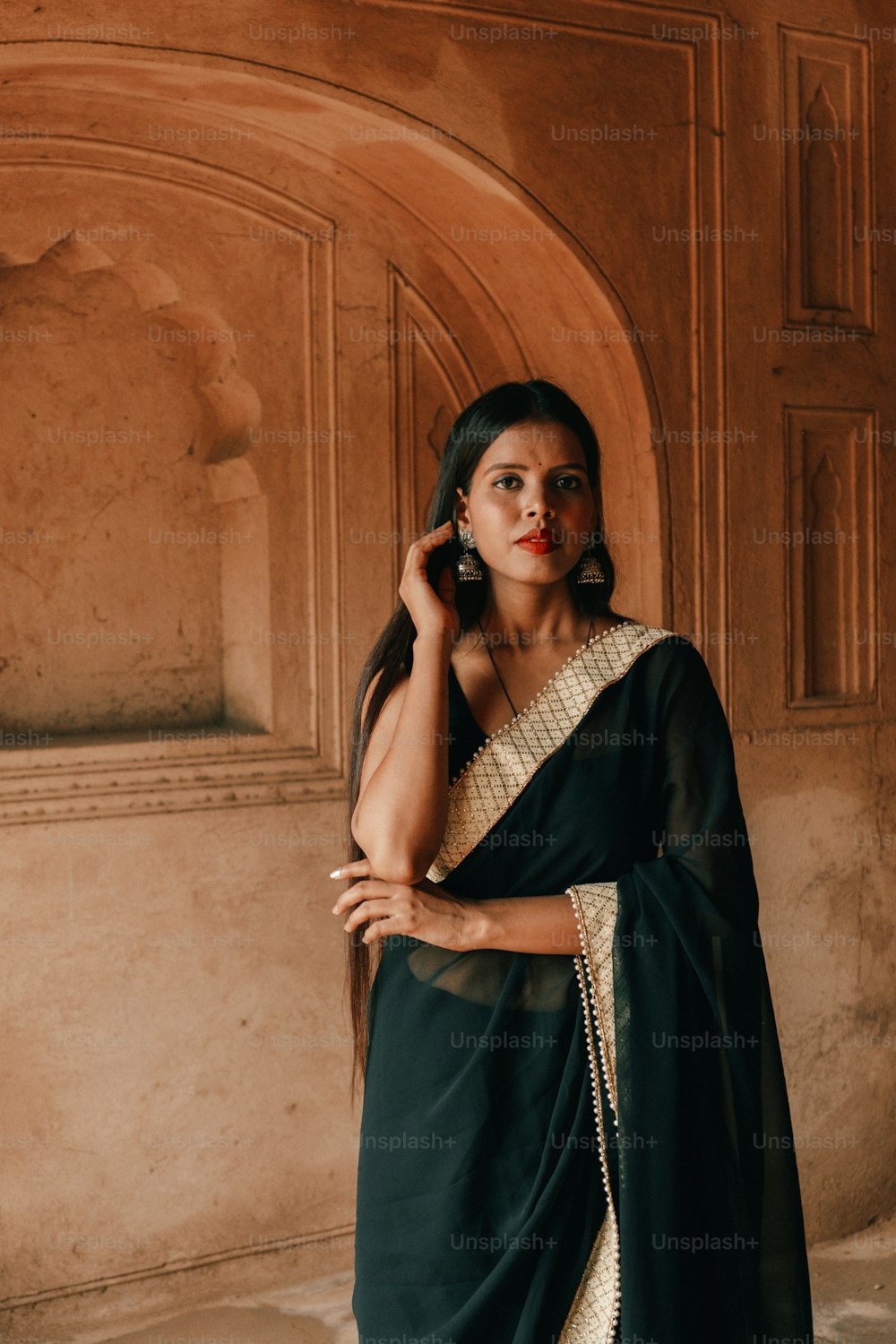 a woman in a black sari is talking on a cell phone