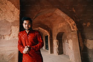 a man in a red shirt standing in a tunnel