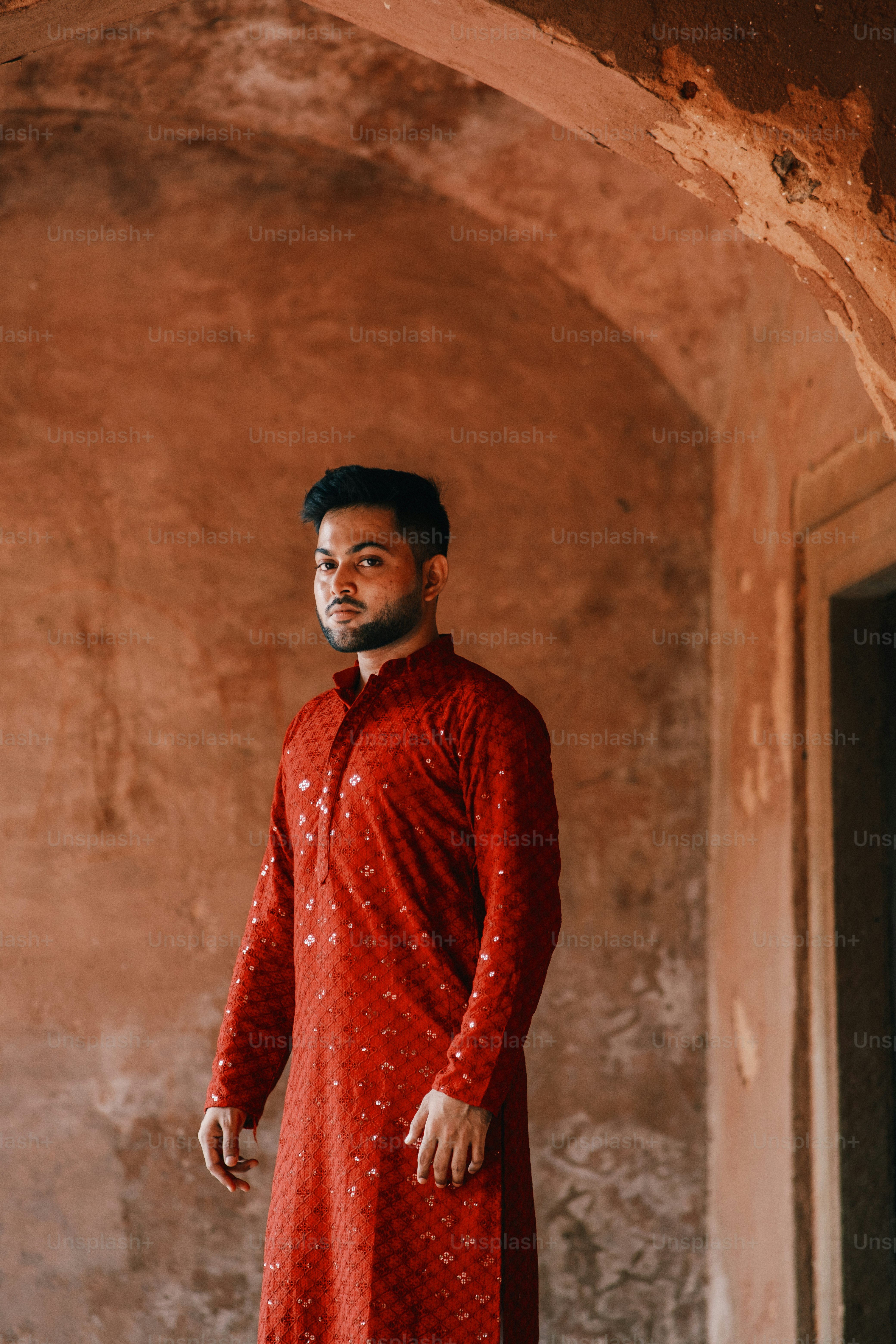 a man in a red dress standing in a doorway