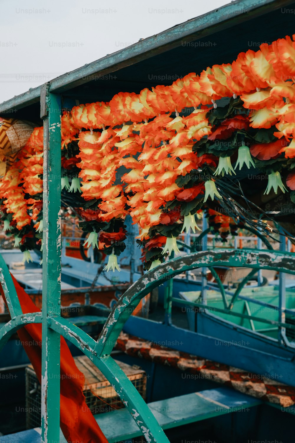 a bunch of orange flowers hanging from a metal structure