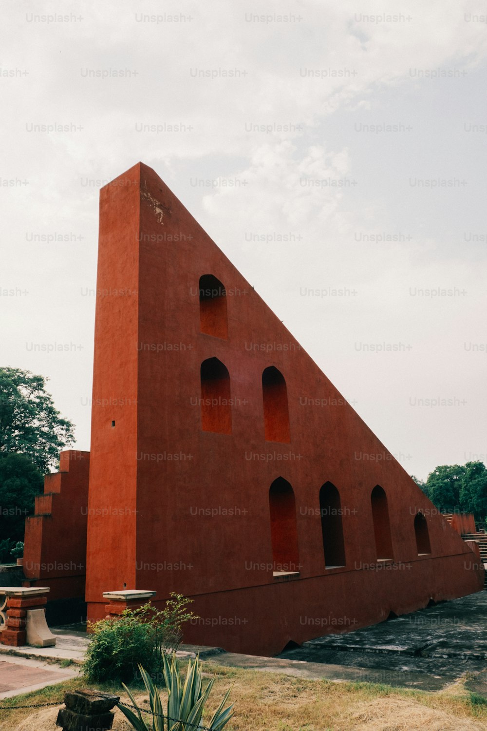 Un gran edificio rojo con una forma triangular en la parte superior