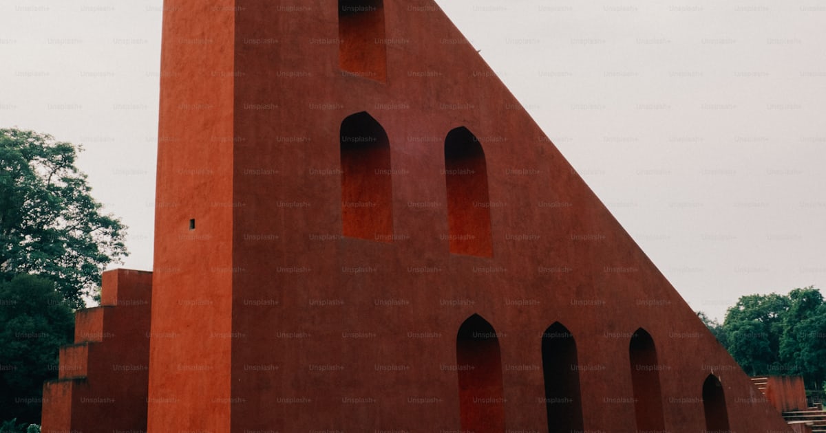 A large red building with a triangular shape on top of it photo ...