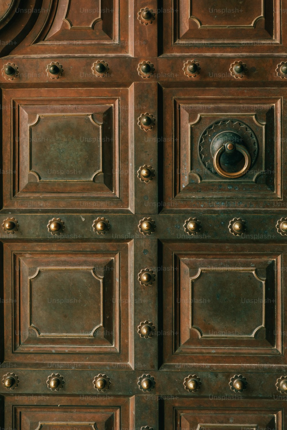 a close up of a wooden door with metal knobs