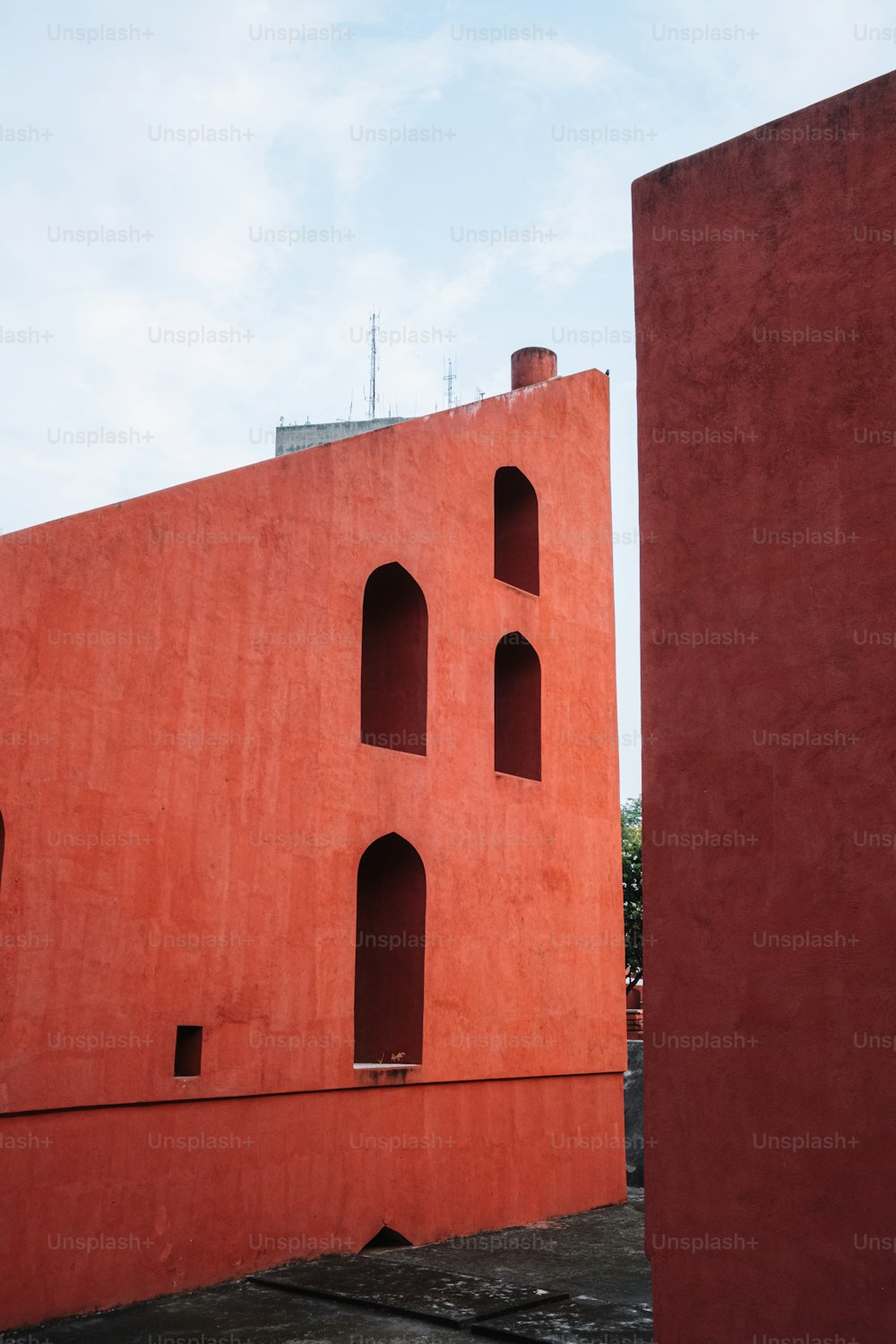 a red building with a clock on the side of it