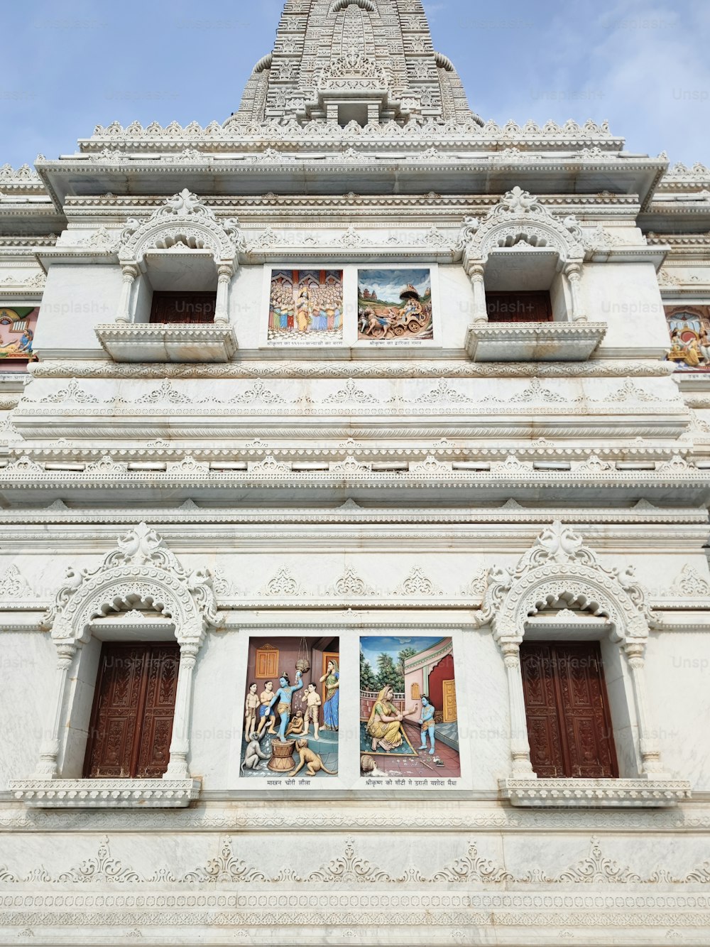 a tall white building with pictures on the side of it