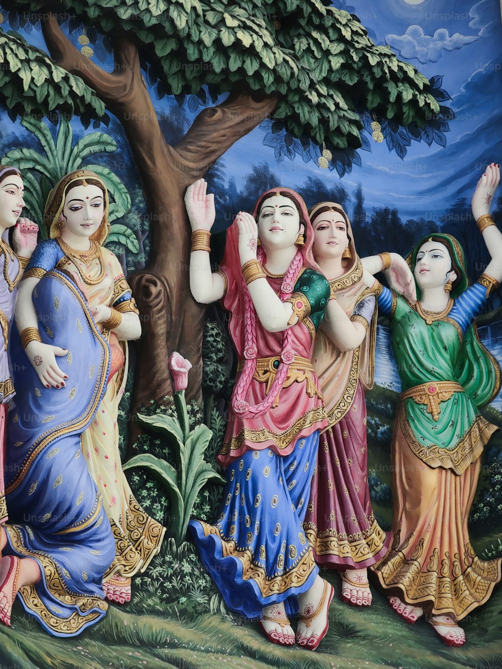 Ein Gemälde einer Gruppe von Frauen, die vor einem Baum tanzen