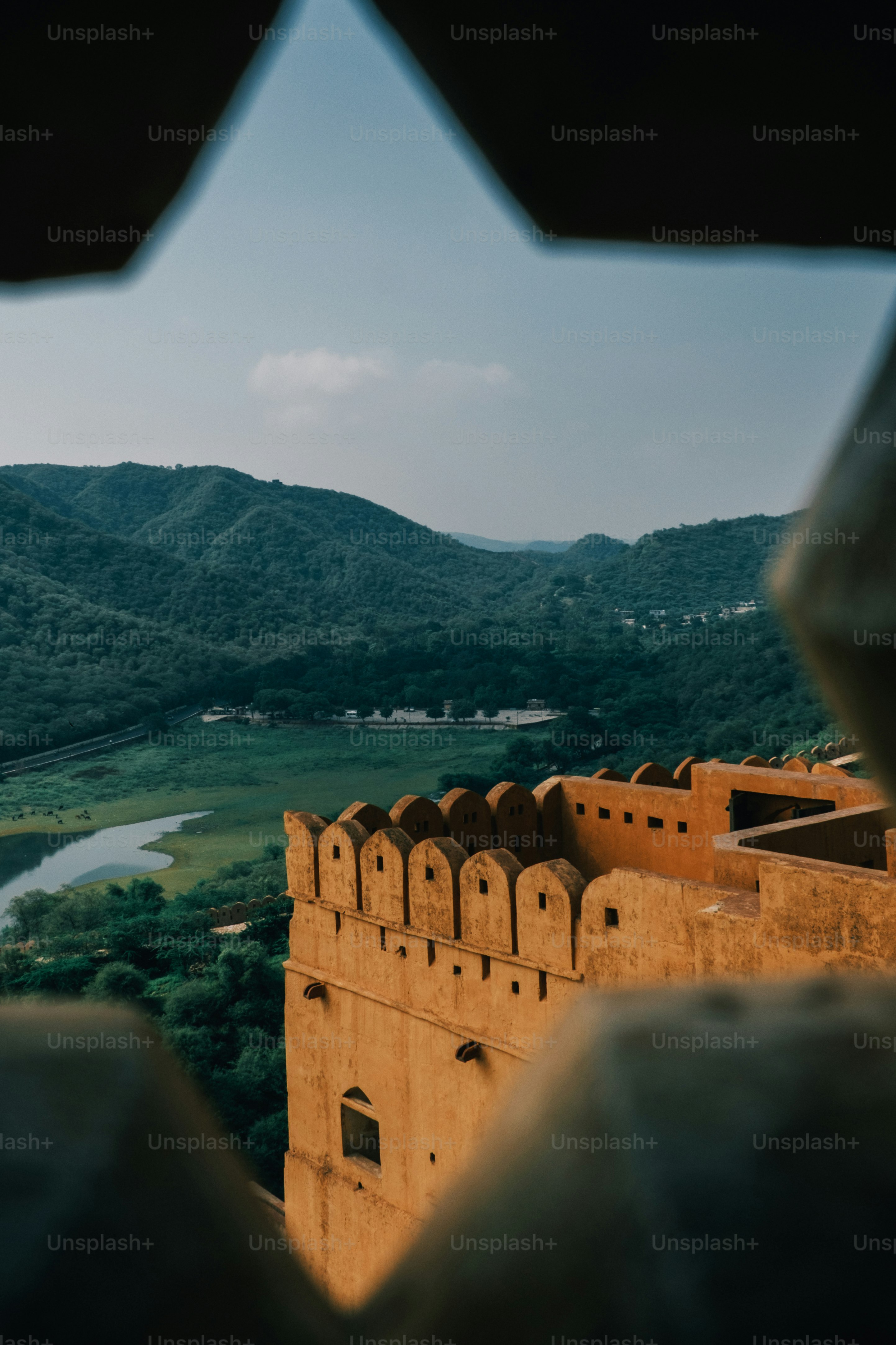 a view from a window of a building with mountains in the background