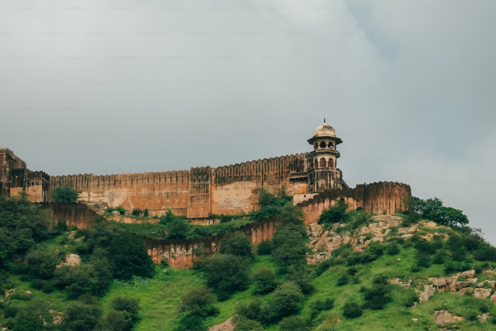 a very tall castle on top of a green hill