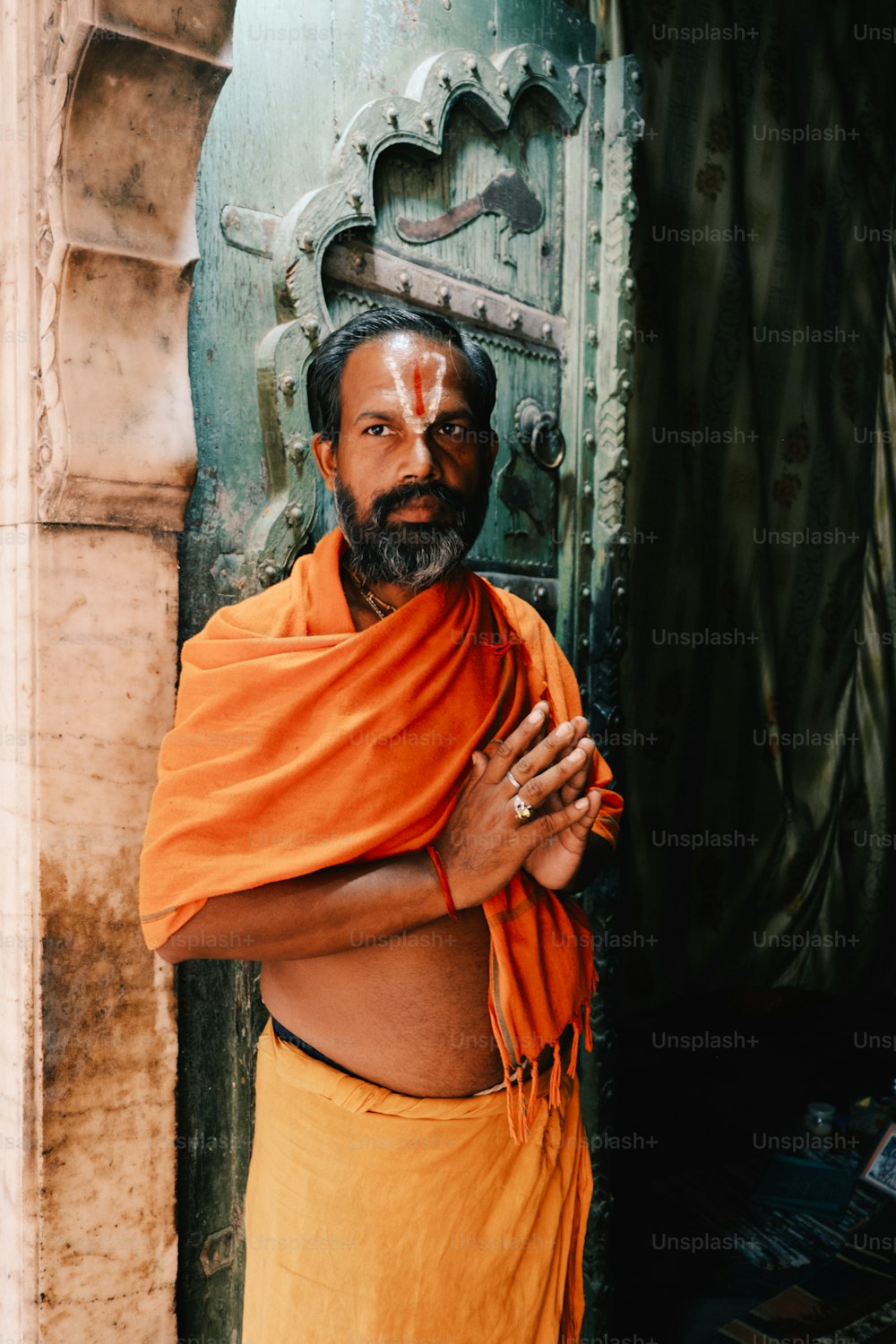 a man in an orange outfit standing in front of a door