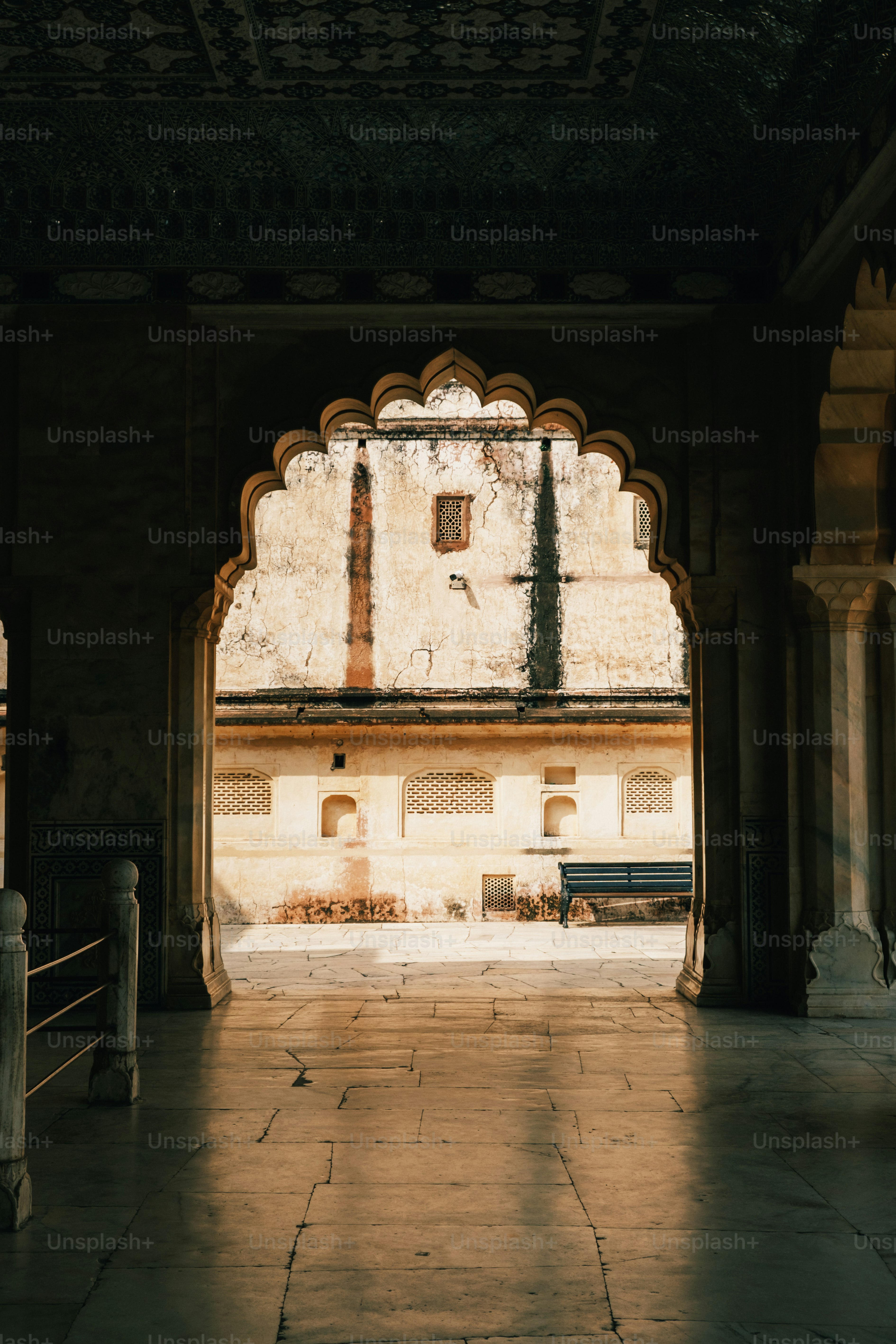 a stone building with a bench in the middle of it