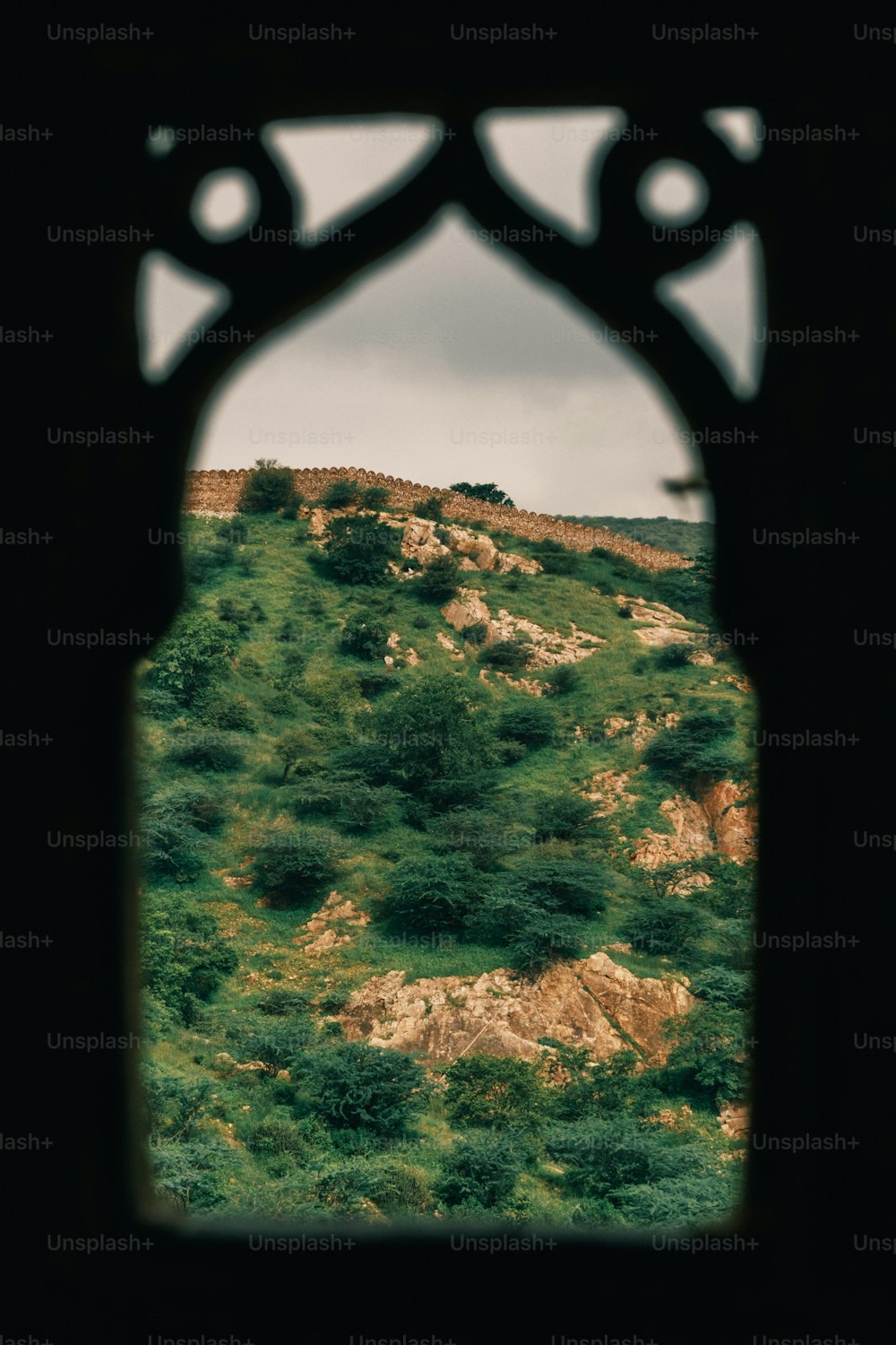 Blick auf einen Hügel durch ein Fenster