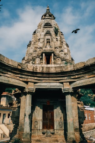 a large stone structure with a bird flying over it