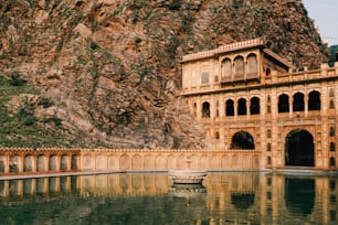 a large building sitting on top of a mountain next to a body of water